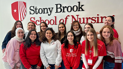 SBSNA Board of Directors standing in front of a Stony Brook School of Nursing sign. 